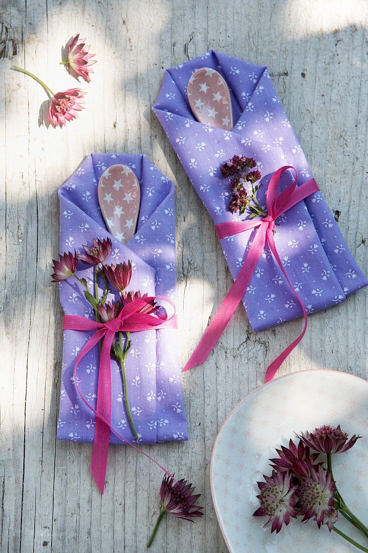 Cutlery bags made from folded napkins and decorated with astrantia