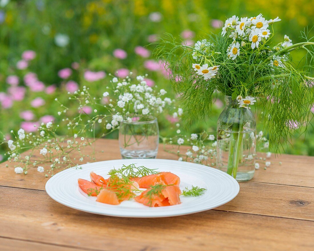 Dill and smoked salmon on a garden table