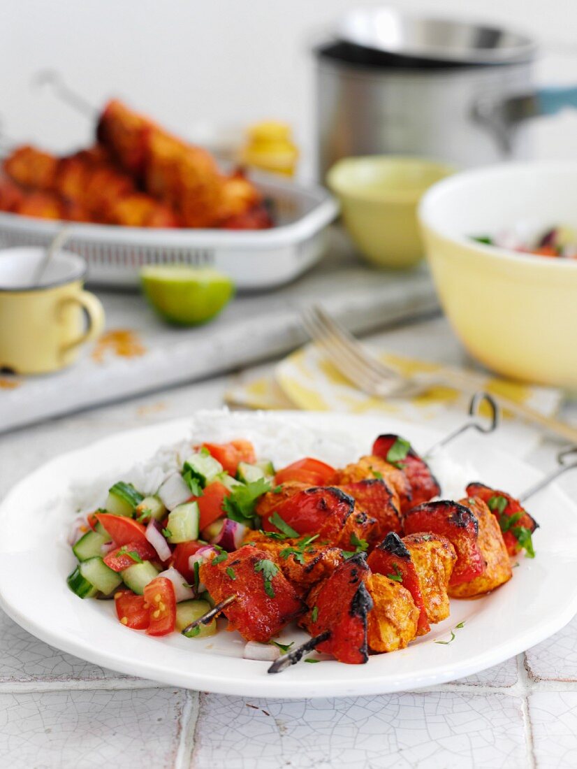 Chicken kebabs with a cucumber and tomato salad