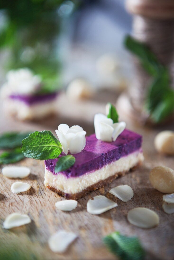 A slice of cheese cake with white chocolate, Macadamia nuts and blueberry cream