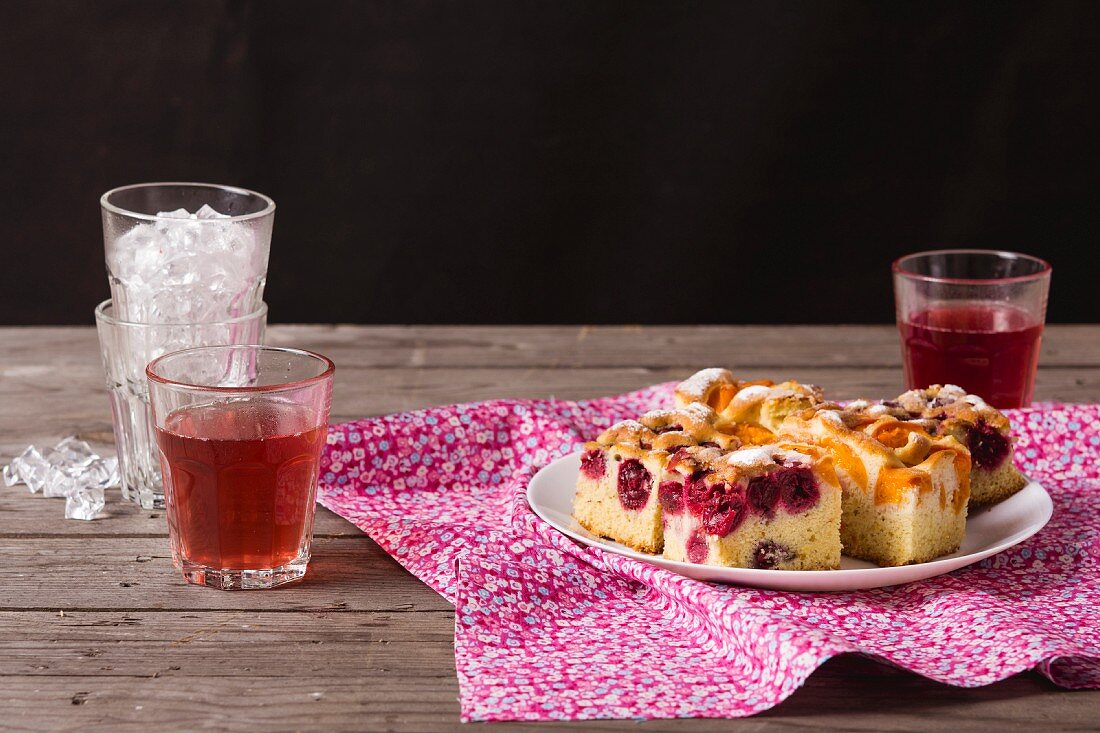 Slices of apricot cake and sour cherry cake with fruit juice