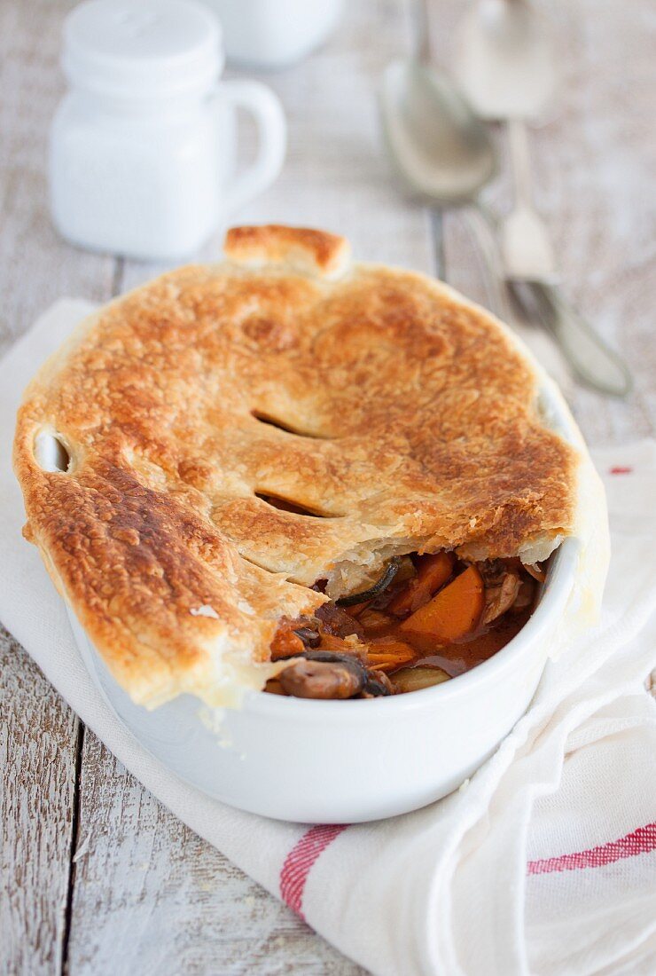 Chicken pot pie with vegetables and a puff pastry lid