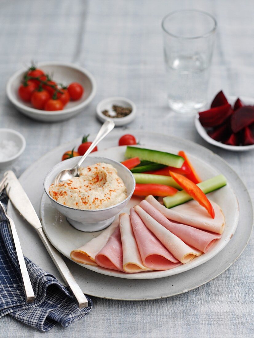 Meat platter with vegetable sticks and houmous