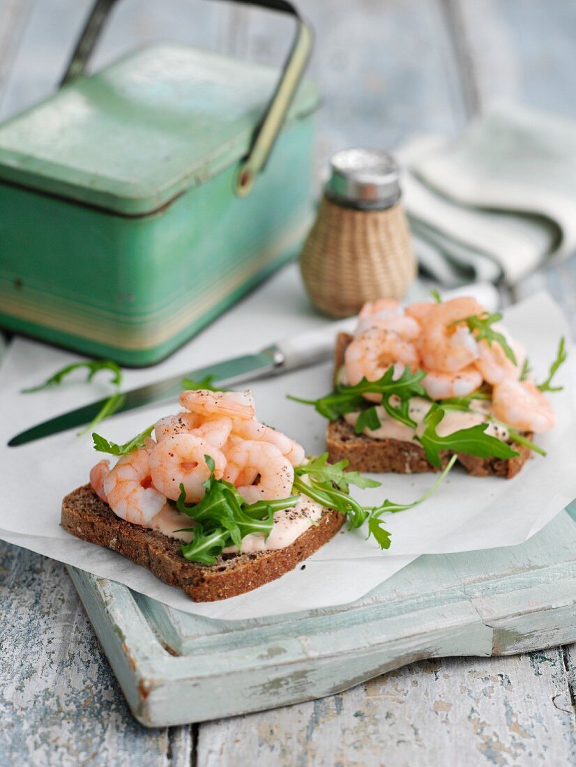 Slices of bread topped with prawns and rocket