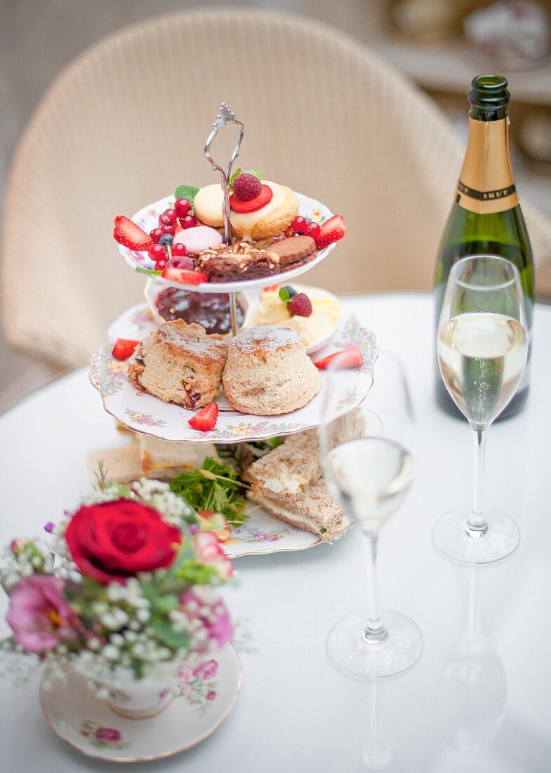 English afternoon tea with sandwiches, scones, petit fours and champagne