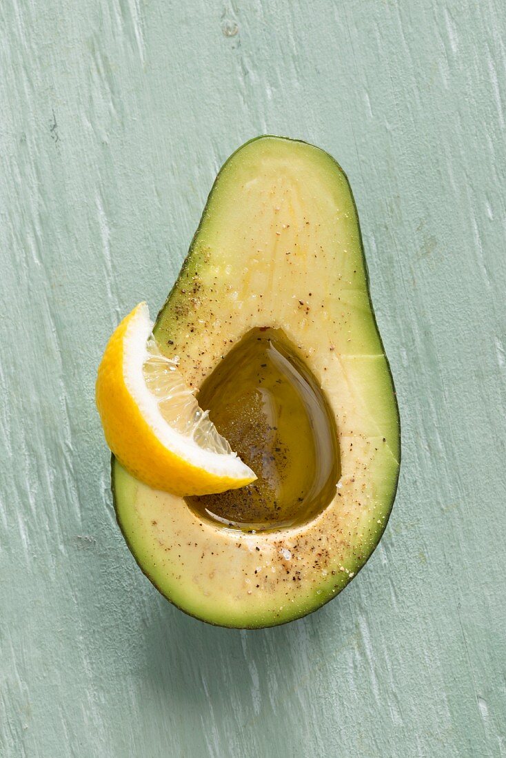 An avocado with olive oil and lemon