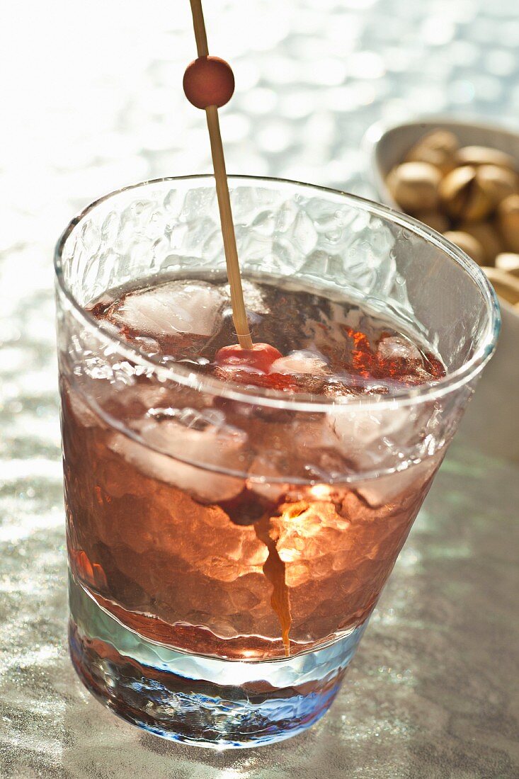 A whiskey cocktail with cherries