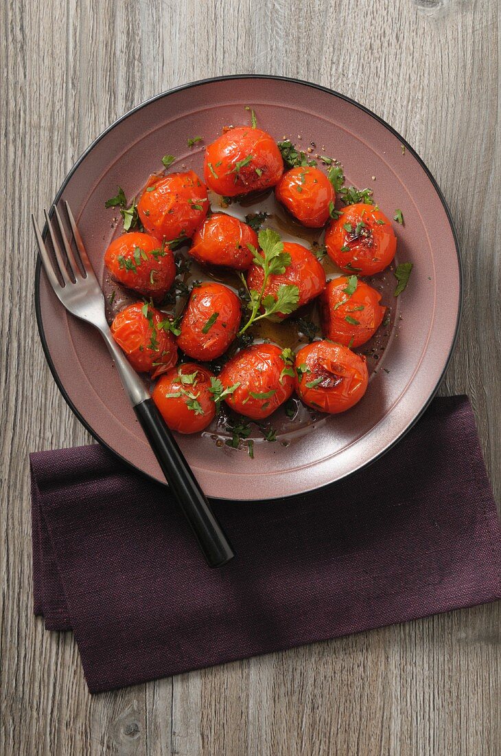 Roasted tomatoes with herbs on a plate