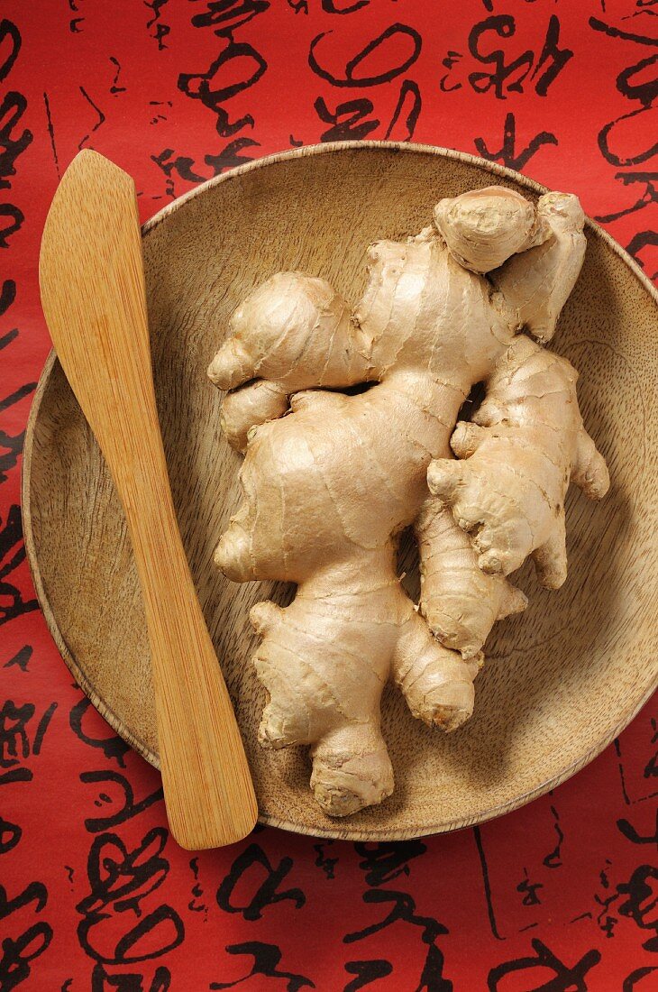 Fresh ginger roots on a wooden plate