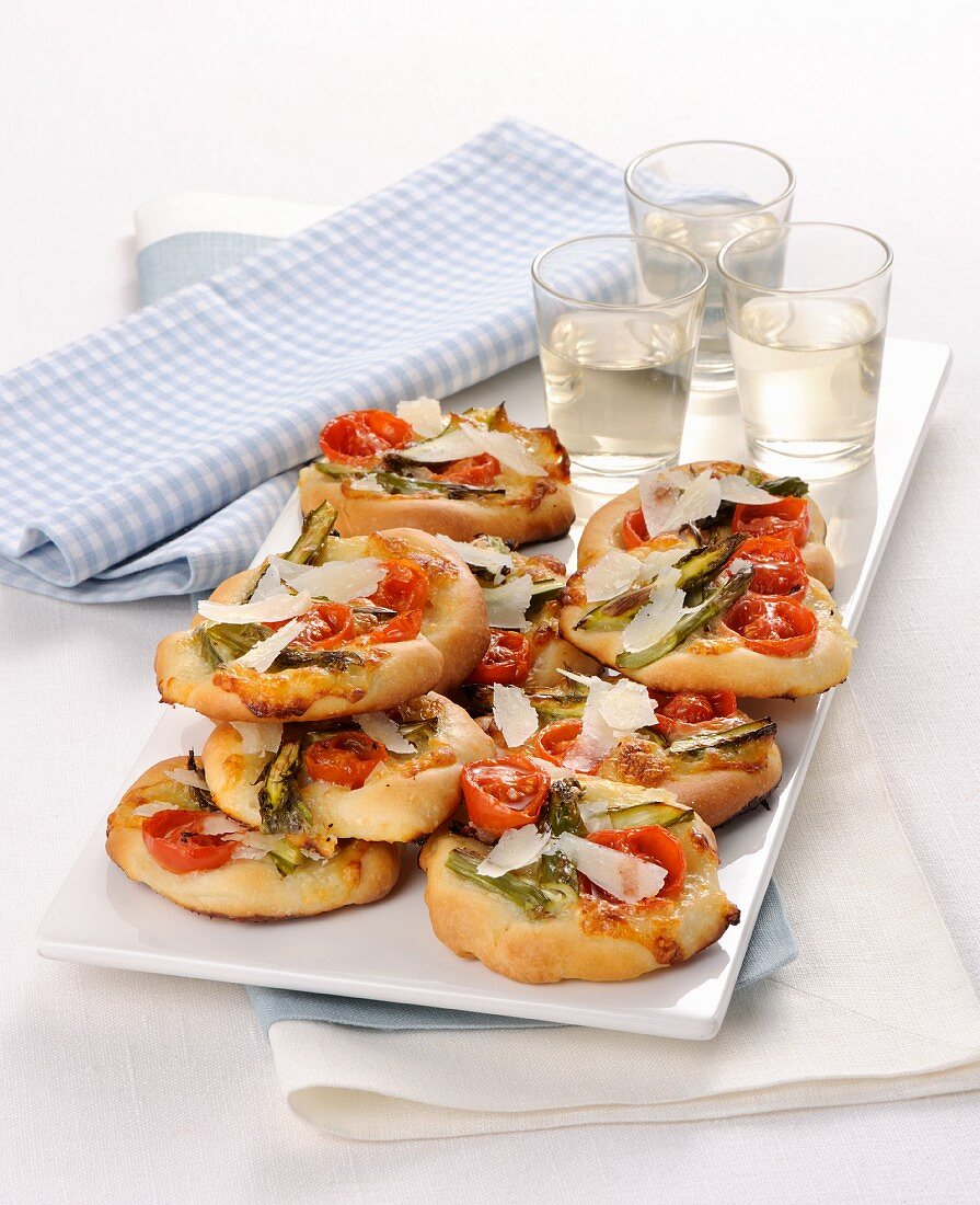 Mini pizzas with green asparagus and cherry tomatoes