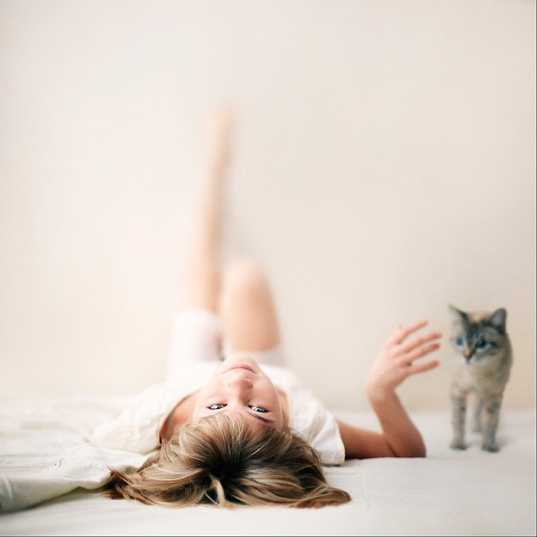 A young girl lying a the floor stroking a cat