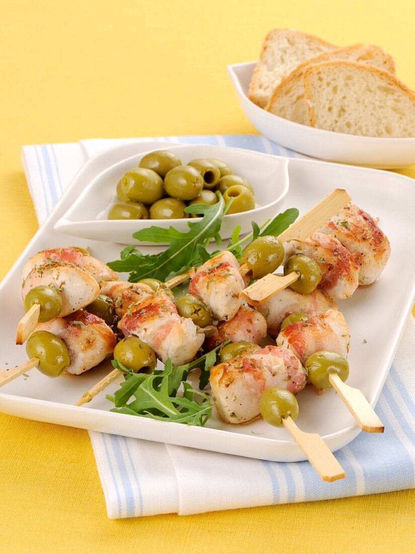 Chicken and bacon kebabs with green olives