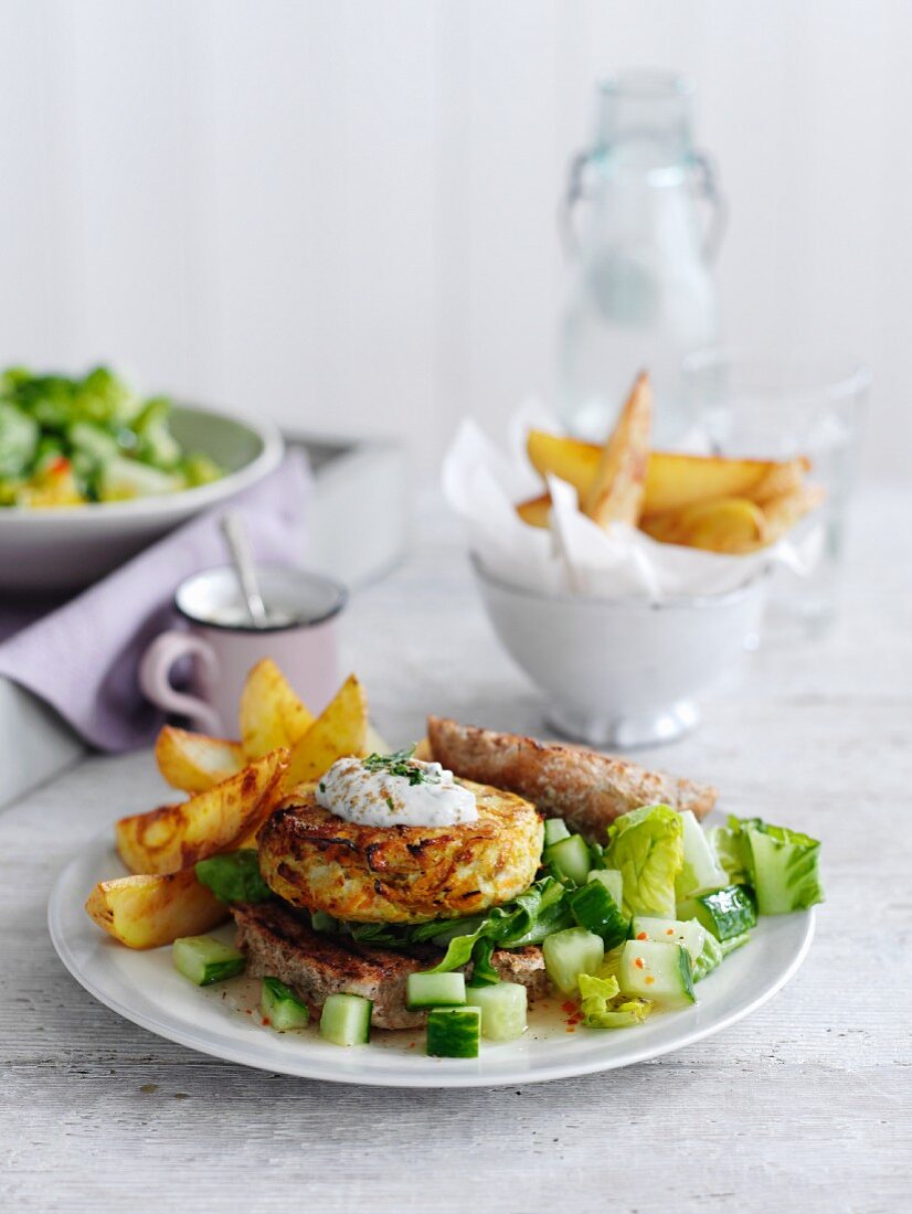 Spicy chicken burger with chips and a cucumber salad