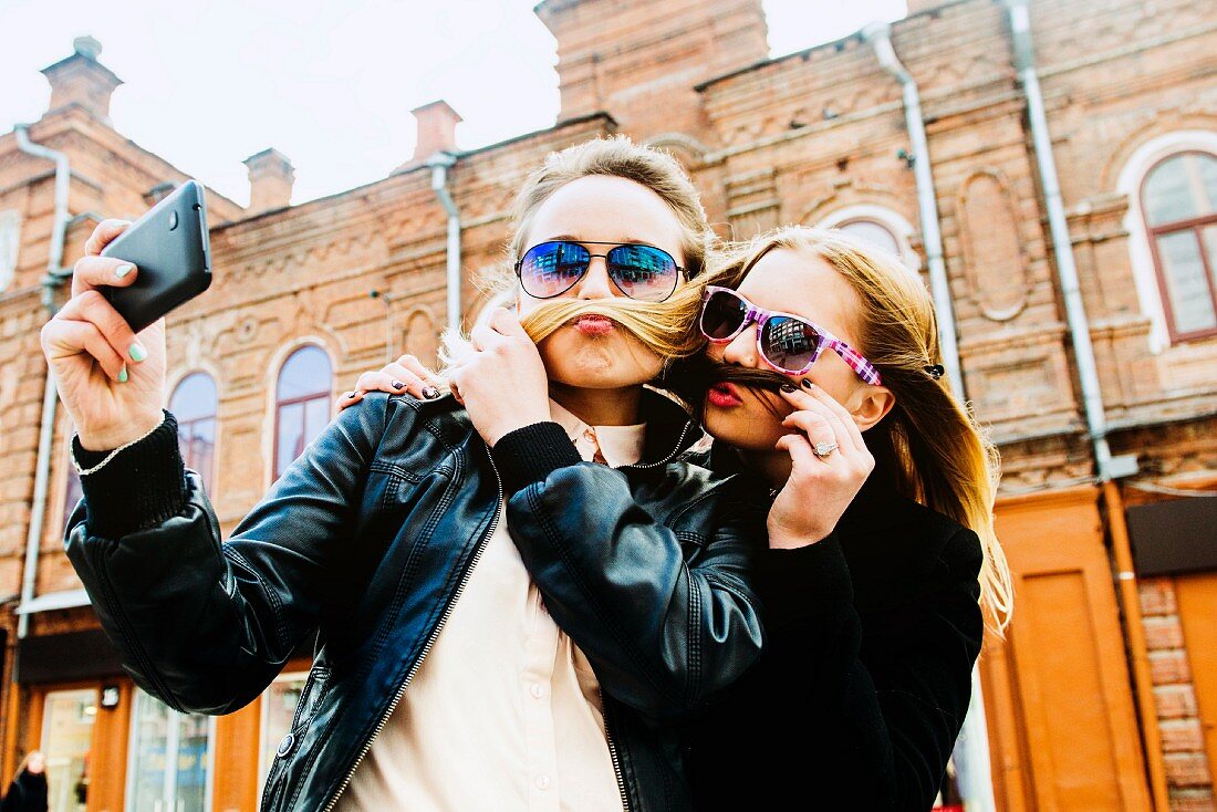 Zwei Mädchen machen ein Selfie in der Stadt