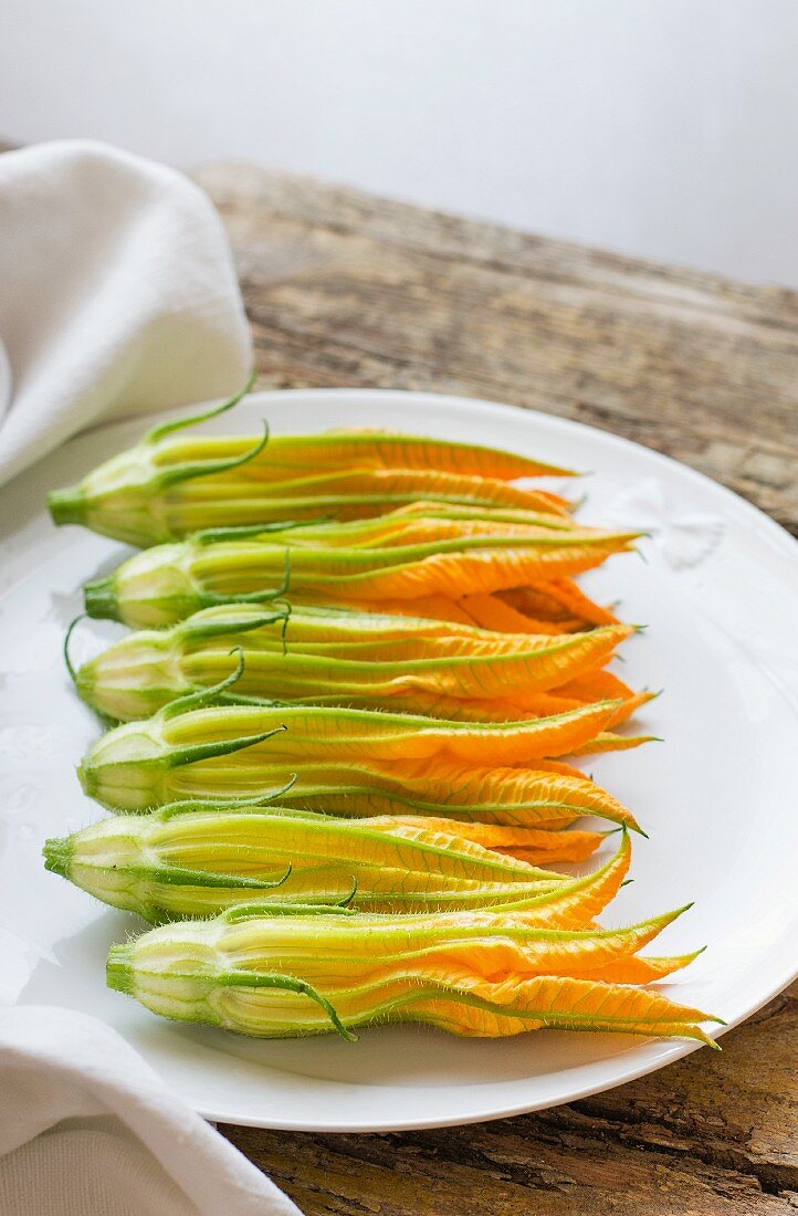 A row of courgette flowers on a plate