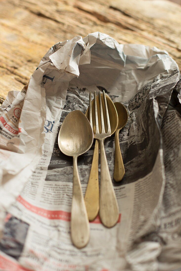 Old cutlery on a piece of newspaper
