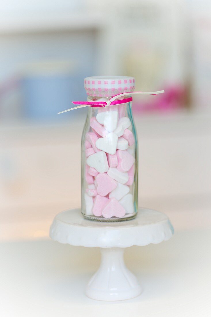 Pink and white peppermint hearts in a small glass bottle