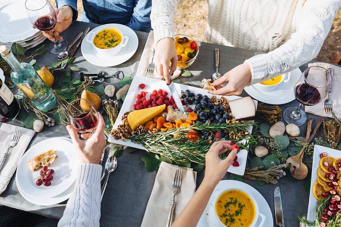 Friends eating together outside an autumnal decorated table