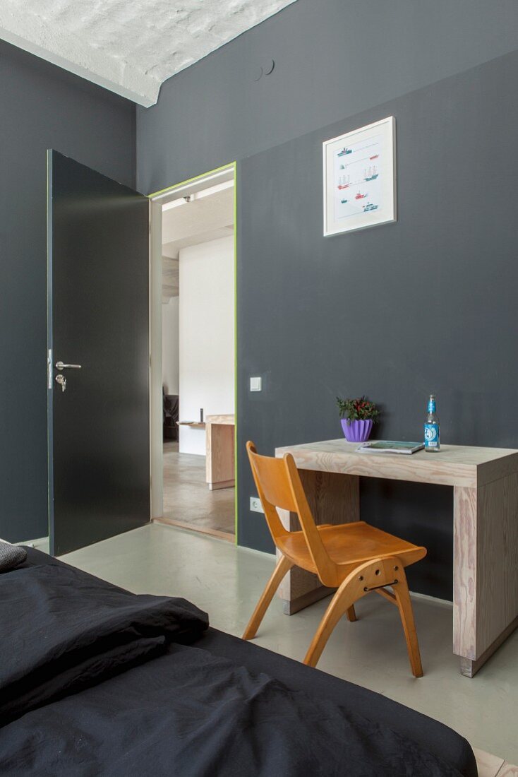Minimalist desk against dark grey wall in bedroom