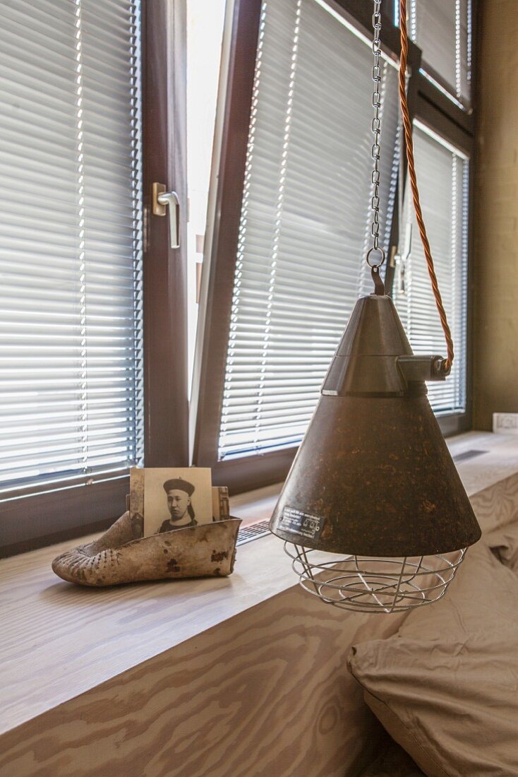 Custom headboard and windowsill, Oriental shoe and photo next to metal pendant lamp