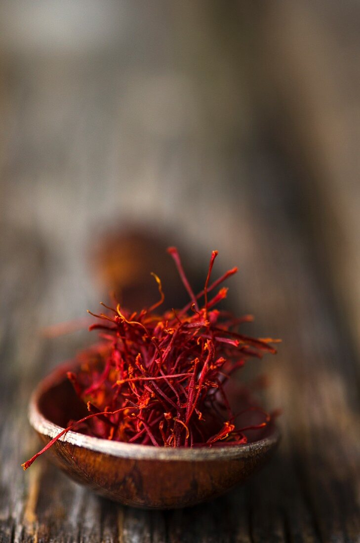 Saffron threads on a wooden spoon (close-up)