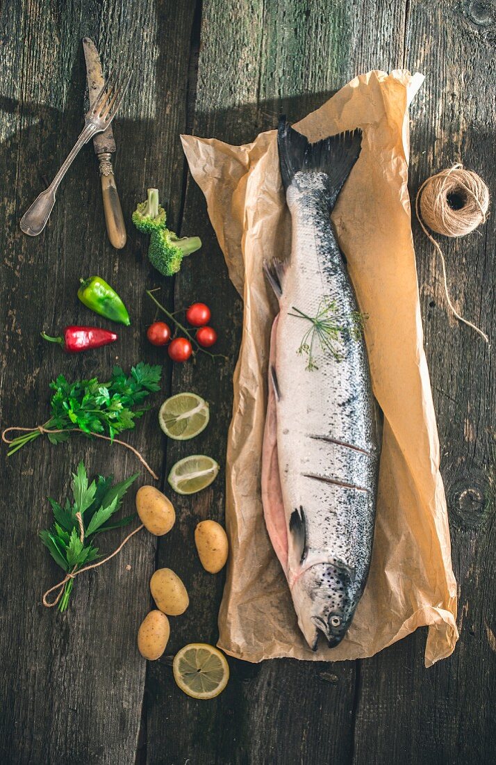 Fresh salmon on a piece of paper next to ingredients (seen above)