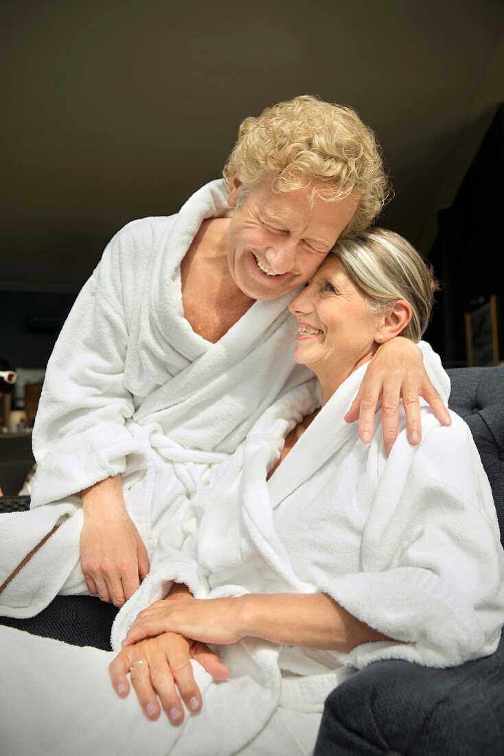 A happy older couple wearing bathrobes