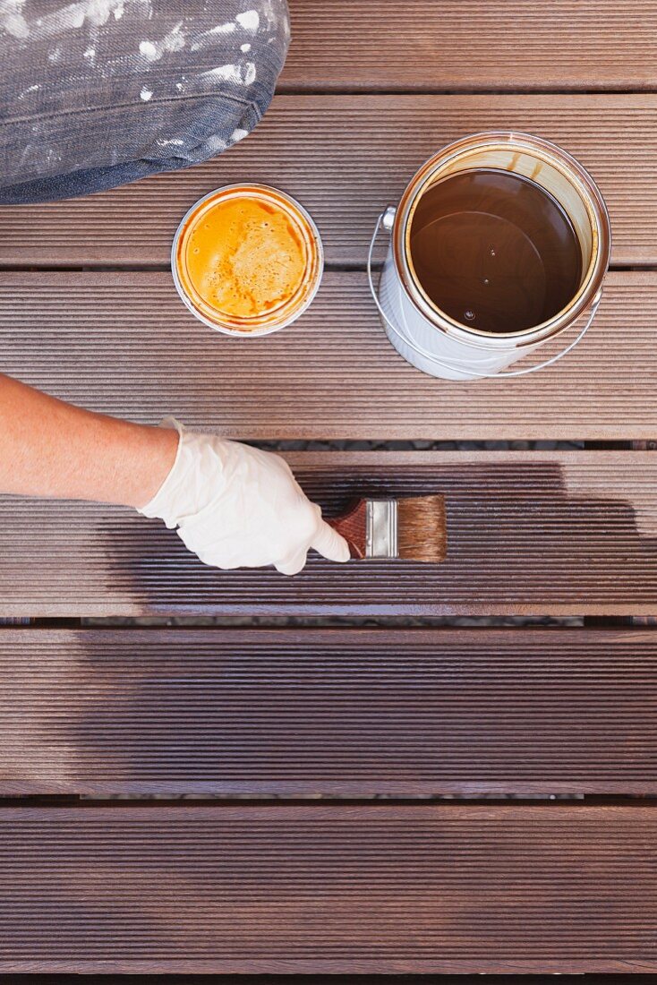 Eine Hand streicht Terrassendielen