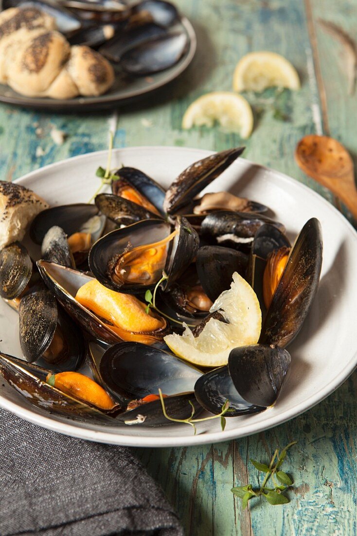 Mussels cooked in their shells served with poppy seed rolls, lemon and thyme