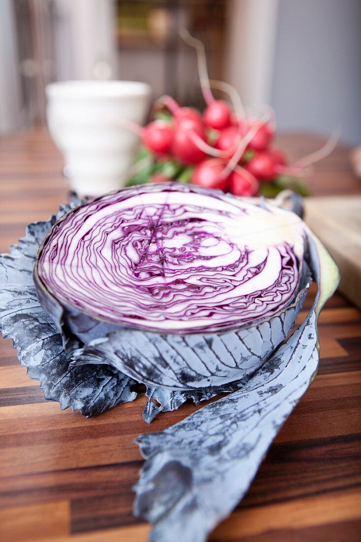 Half a fresh red cabbage on a wooden table in the kitchen