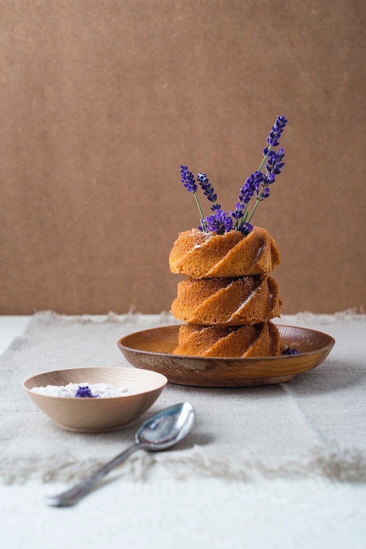 Stapel aus drei Mini-Kranzkuchen dekoriert mit Lavendelblüten und Lavendelzucker