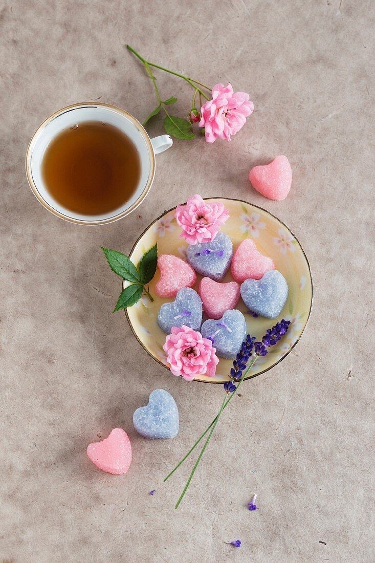 A cup of tea with rose, and lavender sugar hearts
