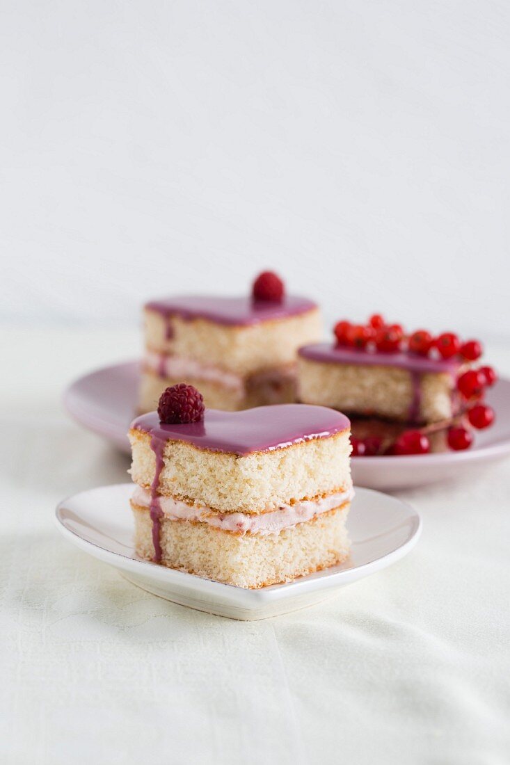 Heart-shaped sponge cakes with raspberry cream and redcurrant jelly