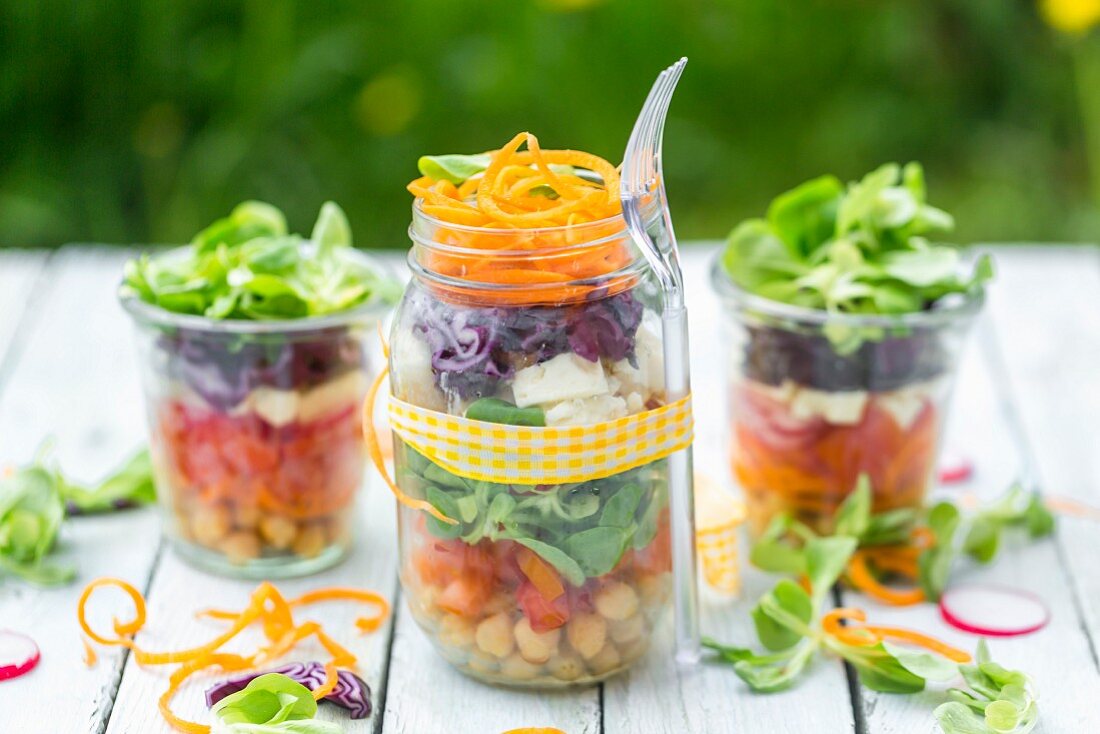 Rainbow salads in glasses with chickpeas, lamb's lettuce and red cabbage