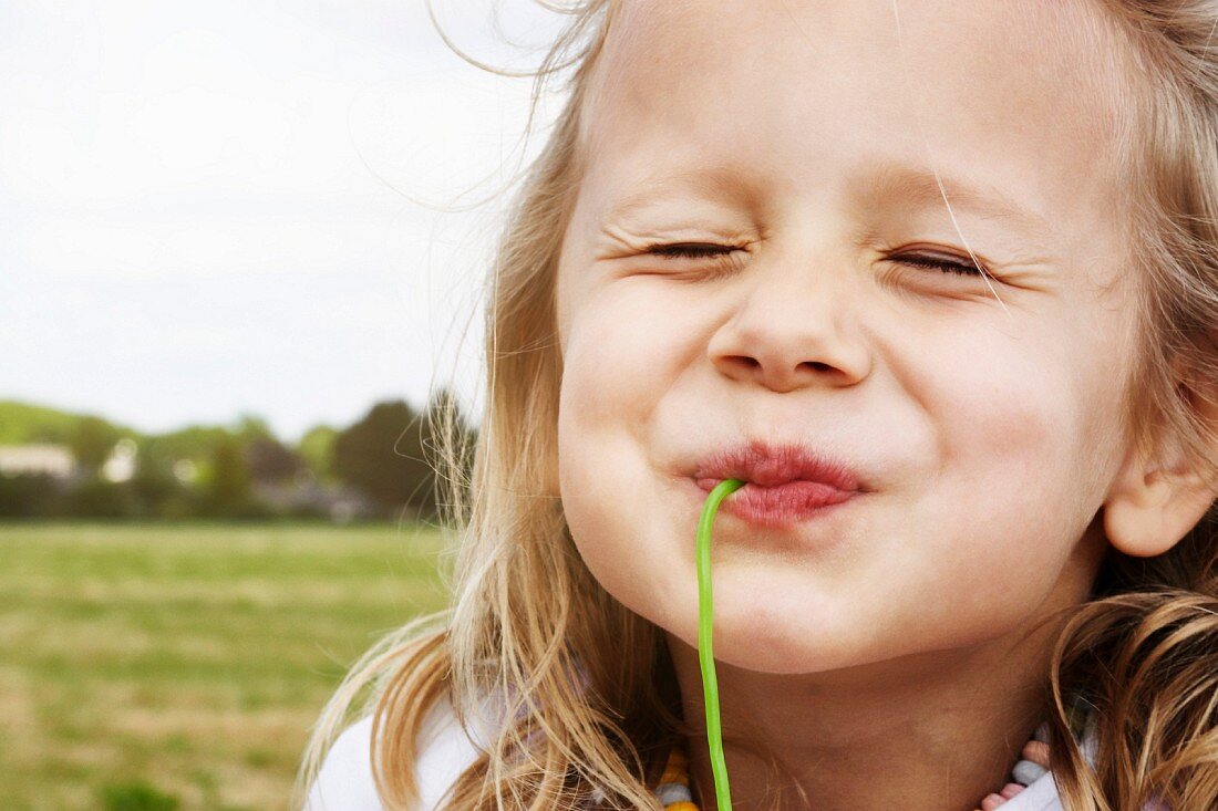 Portrait eines glücklichen kleinen Mädchens beim Essen von Süssigkeiten