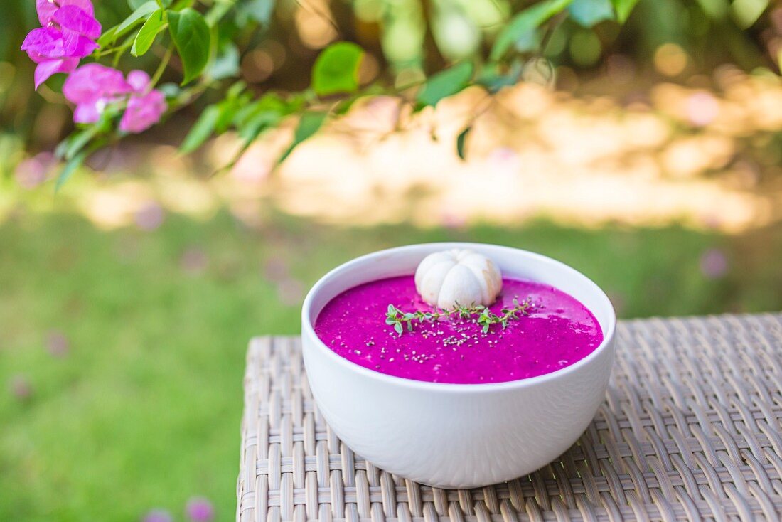 A dragon fruit smoothie bowl on a table outside