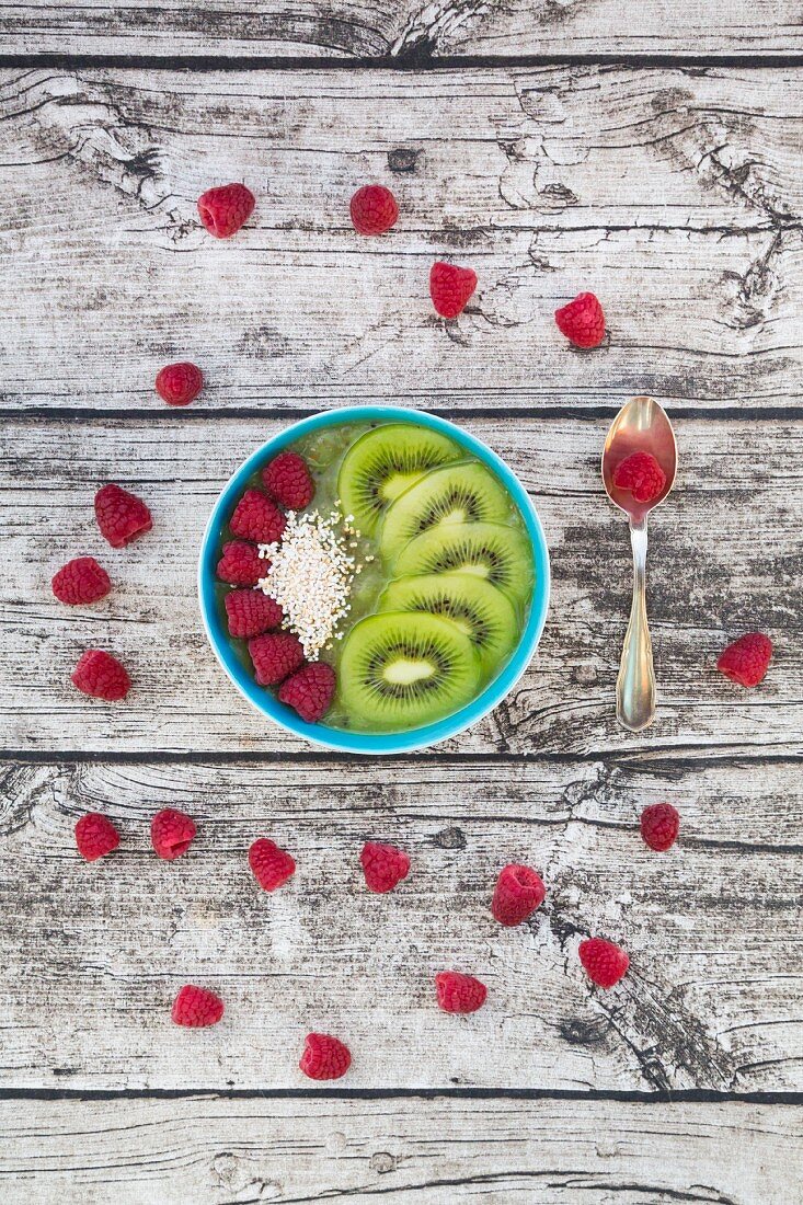 A smoothie bowl with amaranth, chia seeds, raspberries and kiwi (seen from above)