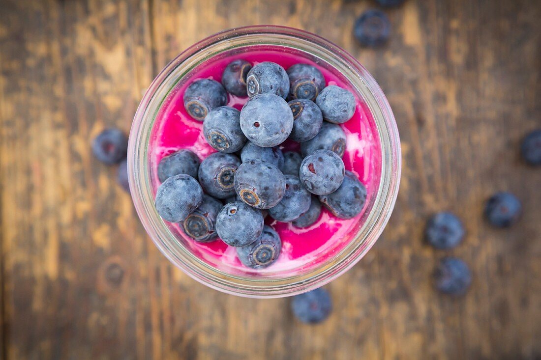 Overnight oats with blueberries and berry juice in a jar (seen from above, close-up)
