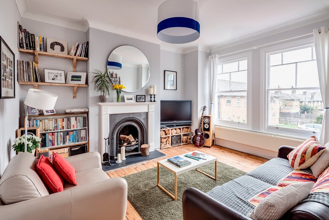 Open fireplace and huge windows in eclectic living room