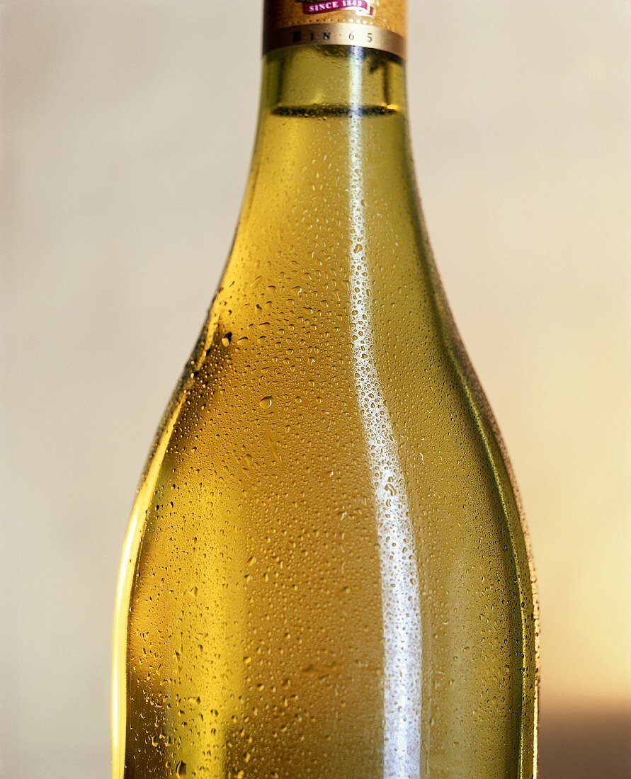 Ausschnitt einer Flasche Weißwein vor hellem Hintergrund