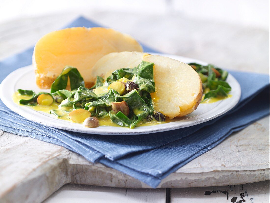 A baked potato with chard in a saffron sauce