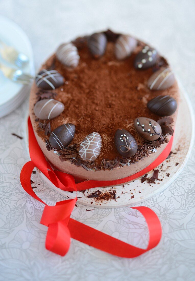 Chocolate Easter cake decorated with chocolate eggs and a red ribbon