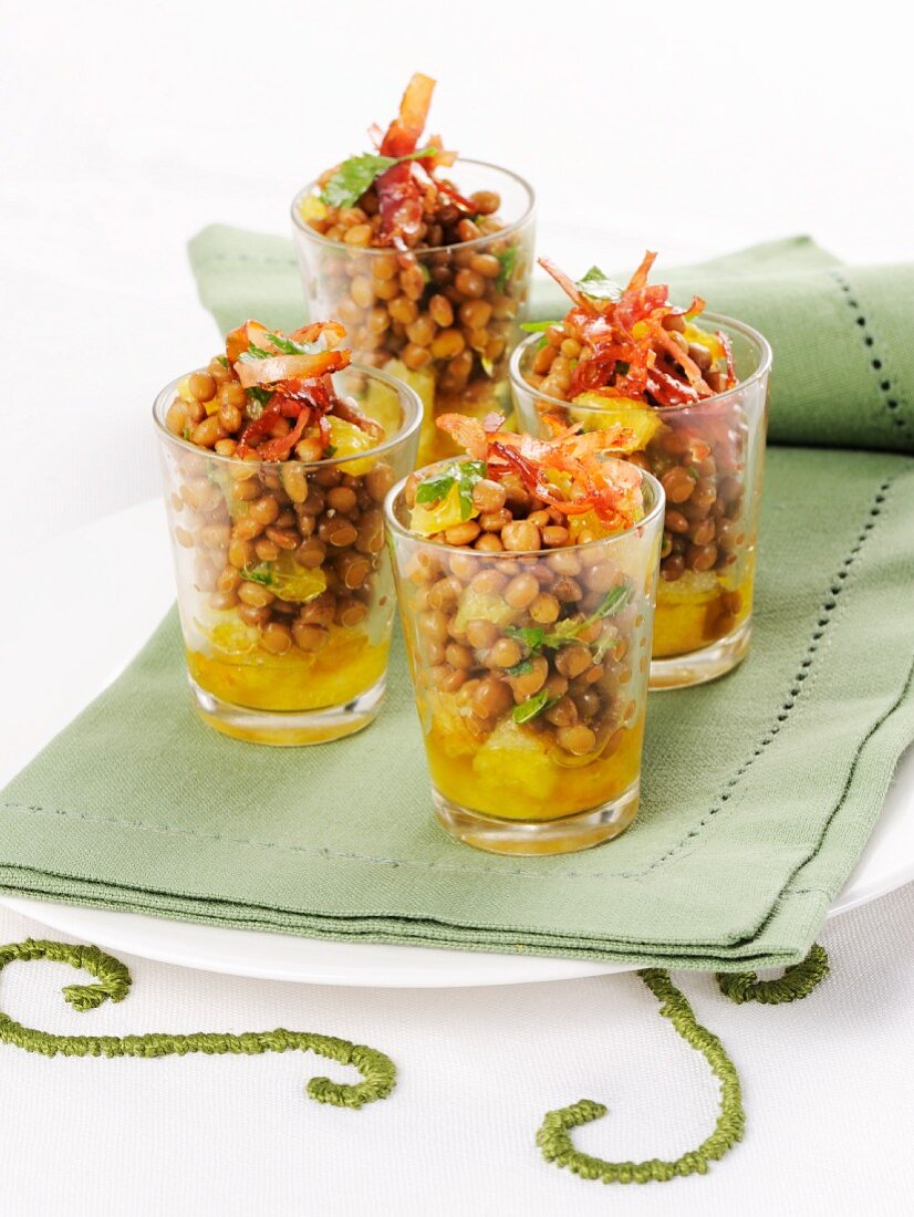 Lentil salad with oranges and strips of ham served in glasses