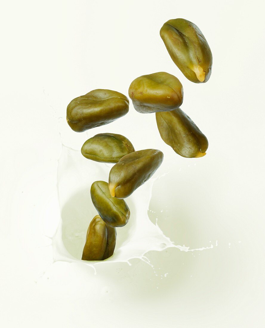Pistachio nuts falling into pistachio milk