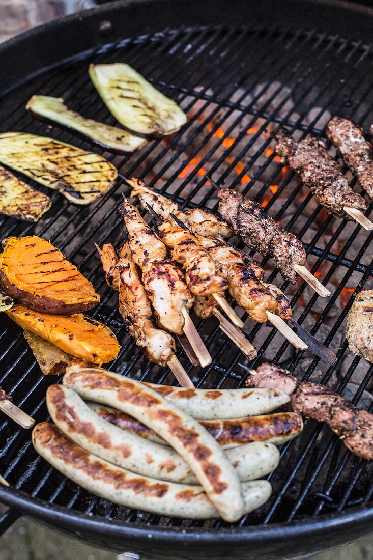 Grilled kebabs, sausages and vegetables on a barbecue