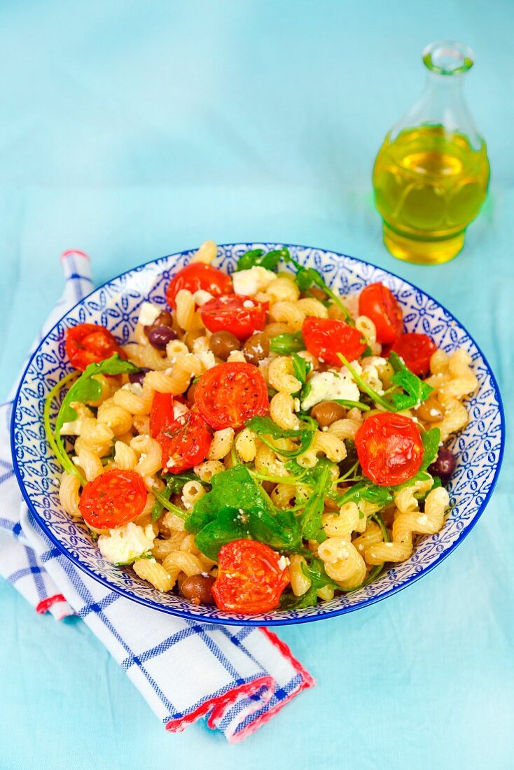 Nudeln mit gedünsteten Tomaten, Feta, Oliven und Rucola