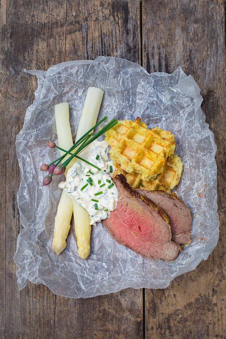 Potato waffle with white asparagus, roast beef and sauce