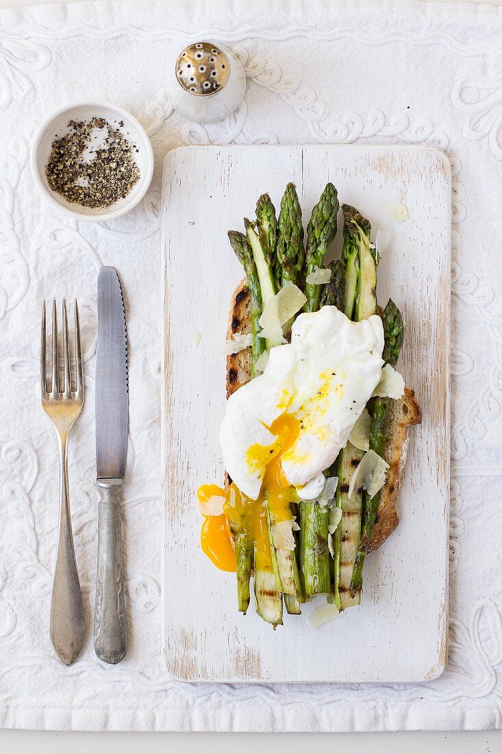 Grilled asparagus with Parmesan cheese and a poached egg on toasted bread
