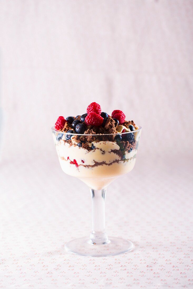 Dessert with berries and chocolate biscuit crumbs