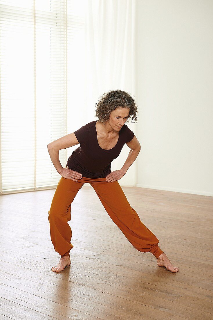 Circling the head (qigong) – Step 2: turn hips to the right, bend knees, bend upper body forward